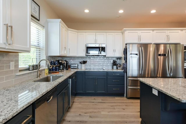 280 Lakefront Dr, Branson, MO 65616 - kitchen with stainless steel appliances, white cabinets, light wood-style floors, decorative backsplash, and light stone countertops