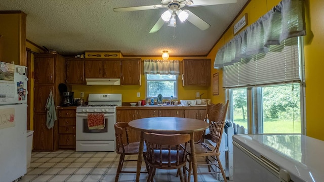 167 Timber Valley Rd, Mammoth Spring, AR 72554 - kitchen with white appliances, under cabinet range hood, brown cabinets, ceiling fan, and a textured ceiling