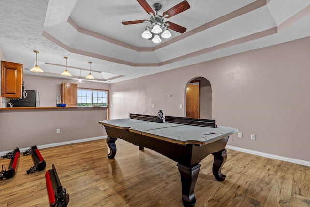 107 W Summit St, Aurora, MO 65605 - recreation room with a tray ceiling, ceiling fan, arched walkways, and light wood-type flooring