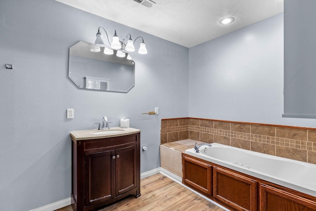 107 W Summit St, Aurora, MO 65605 - bathroom with vanity, a bath, wood finished floors, and a textured ceiling