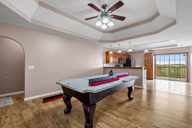 107 W Summit St, Aurora, MO 65605 - rec room with a raised ceiling, a ceiling fan, light wood-type flooring, and arched walkways