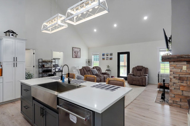 4360 State Highway Ww, Verona, MO 65769 - kitchen with stainless steel dishwasher, high vaulted ceiling, an island with sink, light wood-type flooring, and light countertops
