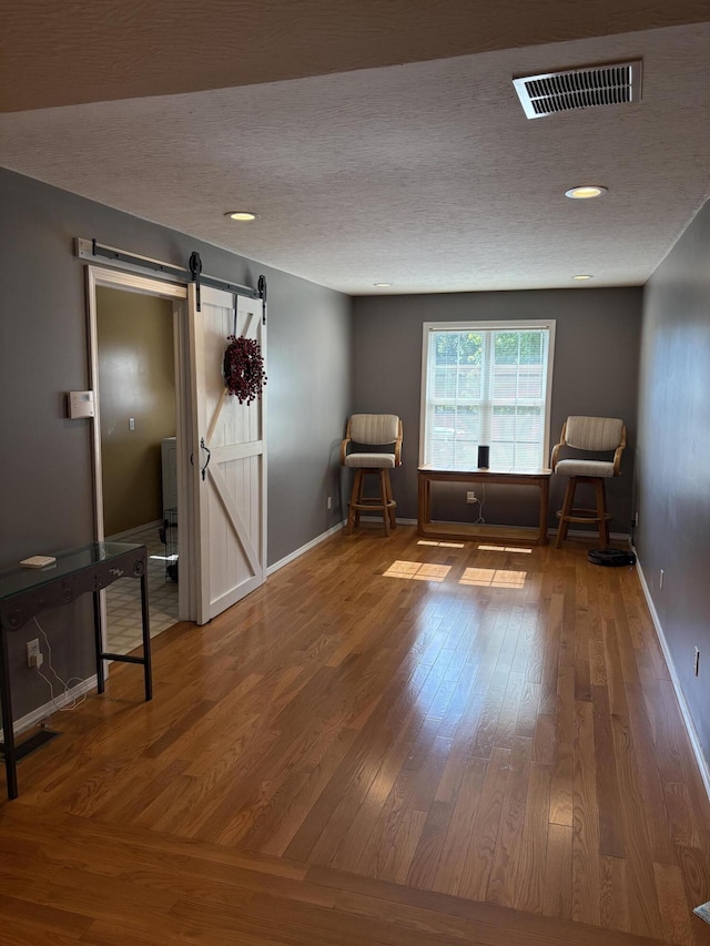 4849 W Rose Hill Rd, Billings, MO 65610 - sitting room with a barn door, wood finished floors, a textured ceiling, and recessed lighting