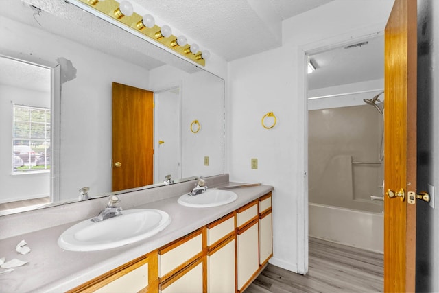 1 Memory Ln Unit 1, Branson, MO 65616 - bathroom with double vanity, wood finished floors, shower / tub combination, and a textured ceiling