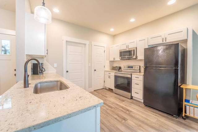 226 W Mount Vernon Rd, Billings, MO 65610 - kitchen with appliances with stainless steel finishes, backsplash, light wood-type flooring, light stone countertops, and white cabinets