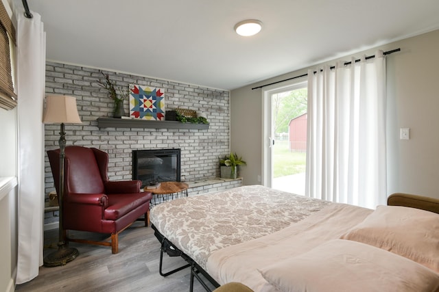 2823 E Catalpa St, Springfield, MO 65804 - bedroom with access to exterior, light wood-style flooring, and a brick fireplace