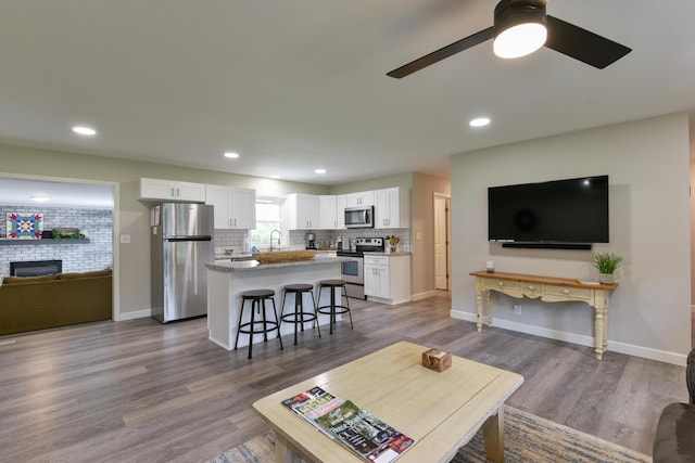 2823 E Catalpa St, Springfield, MO 65804 - living area with a ceiling fan, wood finished floors, a large fireplace, and recessed lighting