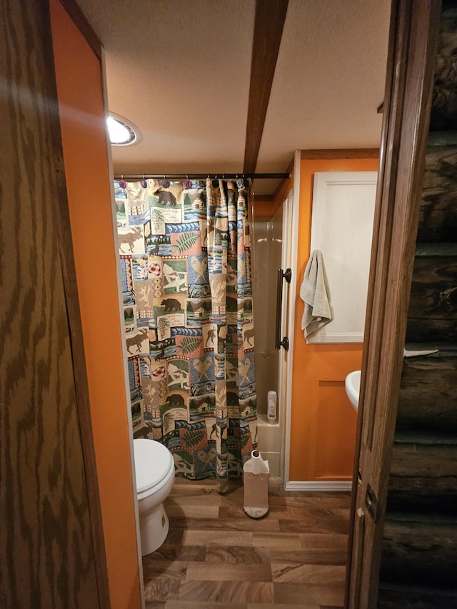 462 Jellystone Ave, Hollister, MO 65672 - bathroom featuring a textured ceiling, wood finished floors, and shower / bathtub combination with curtain