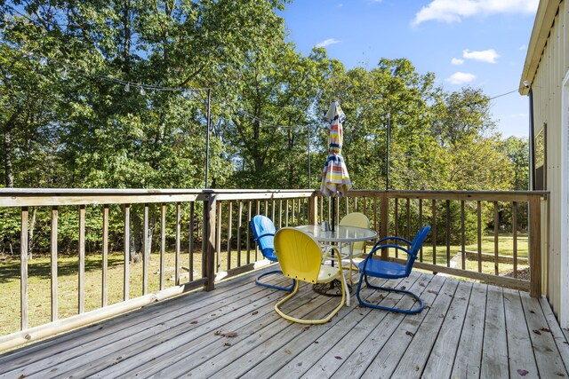 19899 E 1820th Rd, Fair Play, MO 65649 - wooden deck with outdoor dining space and view of scattered trees