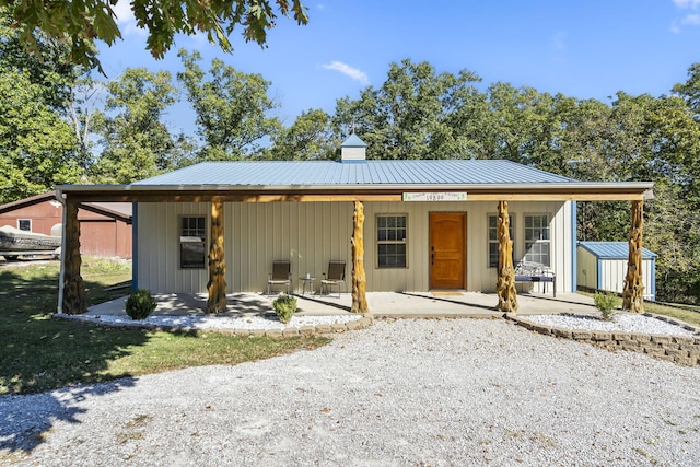 19899 E 1820th Rd, Fair Play, MO 65649 - view of front of home with a shed, a metal roof, covered porch, and a chimney