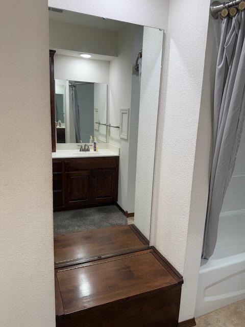 2604 Country Dr, Mountain Grove, MO 65711 - full bath featuring vanity, shower / tub combo with curtain, and a textured wall