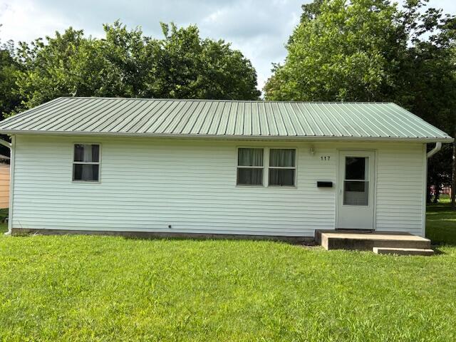 117 E Springfield St, Aurora, MO 65605 - back of house with a metal roof and a lawn