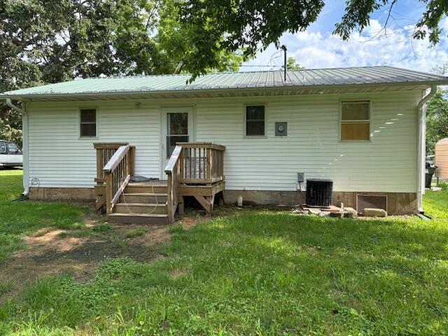 117 E Springfield St, Aurora, MO 65605 - rear view of house featuring a lawn, a metal roof, and a deck