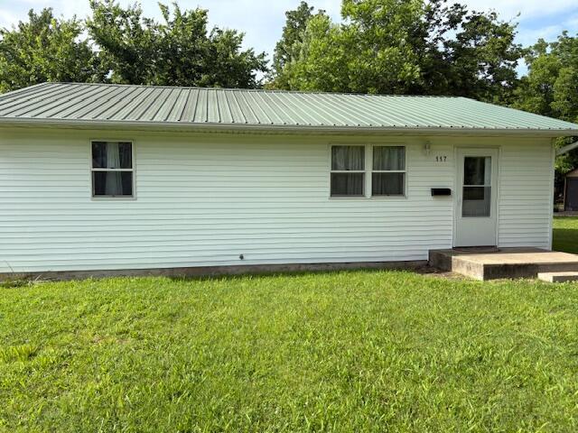 117 E Springfield St, Aurora, MO 65605 - rear view of property with a metal roof and a lawn