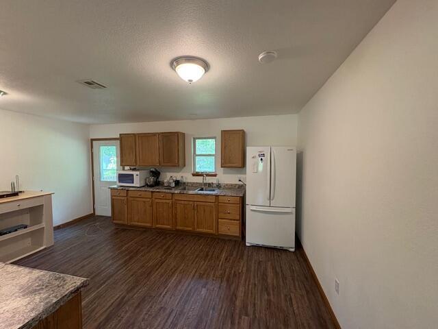 117 E Springfield St, Aurora, MO 65605 - kitchen featuring white appliances, dark wood-type flooring, and brown cabinetry