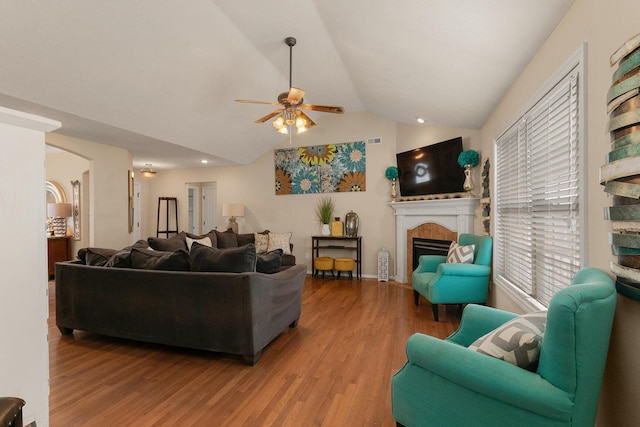 3223 W Melbourne St, Springfield, MO 65810 - living room featuring ceiling fan, wood finished floors, a tile fireplace, lofted ceiling, and arched walkways