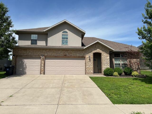 2103 S Gristmill Ct, Ozark, MO 65721 - view of front of property with stone siding, a front yard, a garage, and driveway