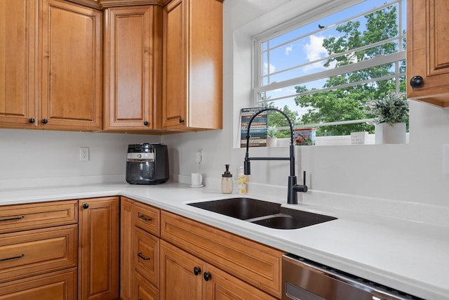 770 Mills Hollow Rd, Branson, MO 65616 - kitchen with stainless steel dishwasher, brown cabinetry, and light countertops