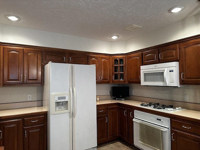 3454 W Countryside Dr, Springfield, MO 65807 - kitchen with white appliances, light countertops, glass insert cabinets, a textured ceiling, and recessed lighting
