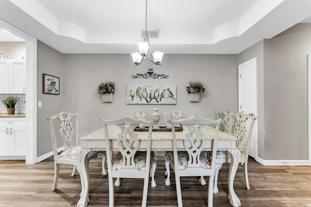 280 W Woodland Dr Unit Ld, Branson, MO 65616 - dining area featuring a raised ceiling, light wood-style floors, and a chandelier