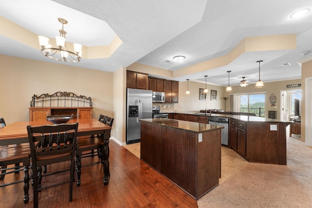 200 Majestic Dr Unit 1-303, Branson, MO 65616 - kitchen featuring stainless steel appliances, dark brown cabinets, a center island, a peninsula, and a chandelier