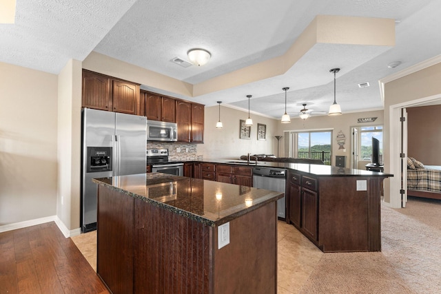 200 Majestic Dr Unit 1-303, Branson, MO 65616 - kitchen with appliances with stainless steel finishes, a peninsula, dark brown cabinetry, a ceiling fan, and decorative light fixtures