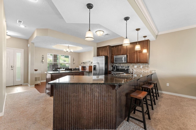 200 Majestic Dr Unit 1-303, Branson, MO 65616 - kitchen with stainless steel appliances, a peninsula, light carpet, dark stone countertops, and tasteful backsplash