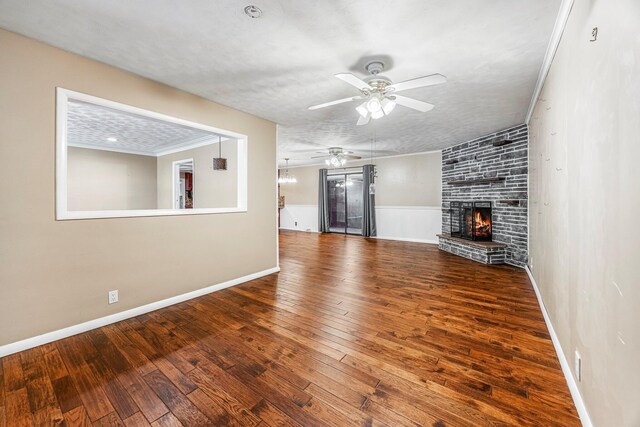 829 W Highland St, Springfield, MO 65807 - unfurnished living room featuring a ceiling fan, a large fireplace, hardwood / wood-style flooring, and crown molding