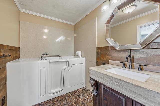 829 W Highland St, Springfield, MO 65807 - full bathroom featuring tile walls, vanity, a garden tub, a textured ceiling, and crown molding
