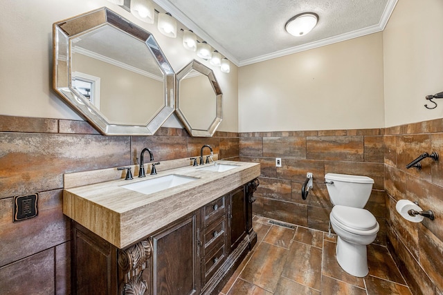 829 W Highland St, Springfield, MO 65807 - bathroom with tile walls, double vanity, wainscoting, crown molding, and a textured ceiling