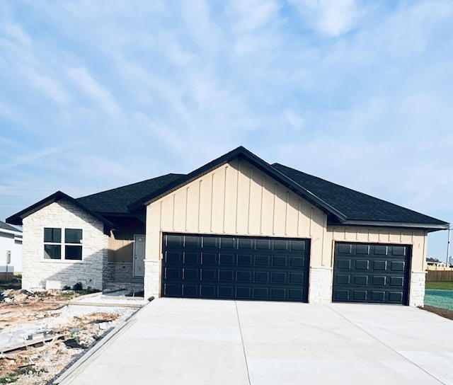 917 S Deerfield Ct, Nixa, MO 65714 - modern farmhouse featuring an attached garage, concrete driveway, board and batten siding, and stone siding