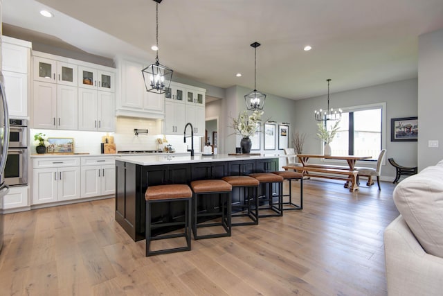 1510 N Lake Edge Dr, Springfield, MO 65802 - kitchen with a chandelier, recessed lighting, light countertops, a kitchen breakfast bar, and tasteful backsplash