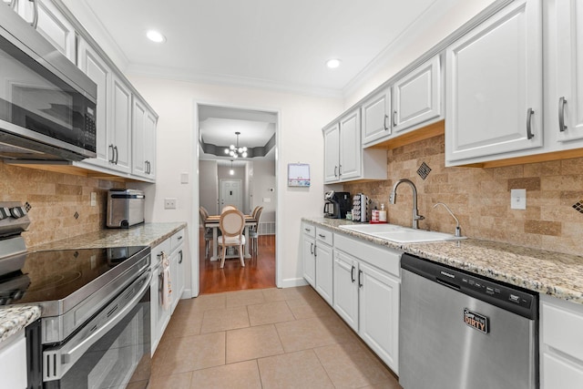 110 Cottonwood Trl Unit 2D, Branson, MO 65616 - kitchen with appliances with stainless steel finishes, a chandelier, ornamental molding, light tile patterned floors, and white cabinets