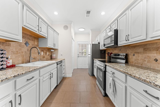 110 Cottonwood Trl Unit 2D, Branson, MO 65616 - kitchen with stainless steel appliances, crown molding, white cabinetry, light tile patterned flooring, and decorative backsplash