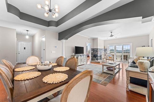 110 Cottonwood Trl Unit 2D, Branson, MO 65616 - dining space featuring a ceiling fan, a stone fireplace, wood finished floors, arched walkways, and ornate columns