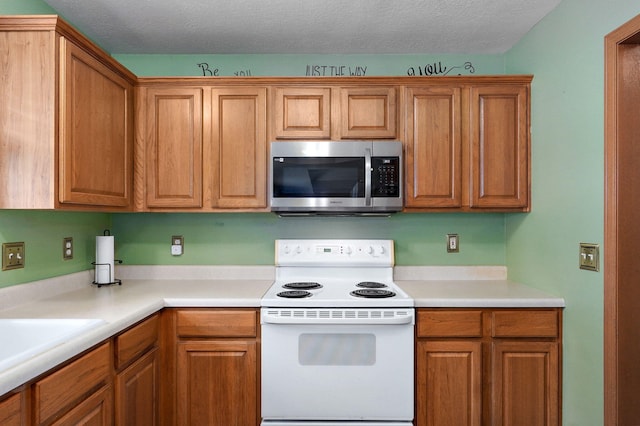608 S Ashwood Ct, Nixa, MO 65714 - kitchen featuring stainless steel microwave, white range with electric cooktop, light countertops, brown cabinets, and a textured ceiling