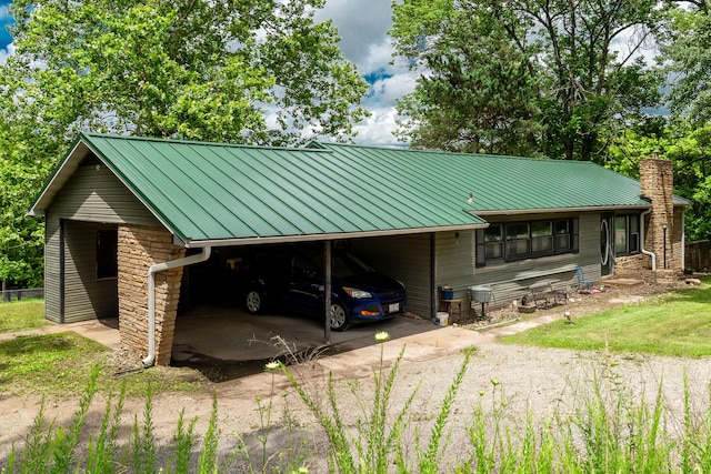 705 Preacher Roe Blvd, West Plains, MO 65775 - view of front of house with a metal roof, driveway, stone siding, a carport, and a chimney