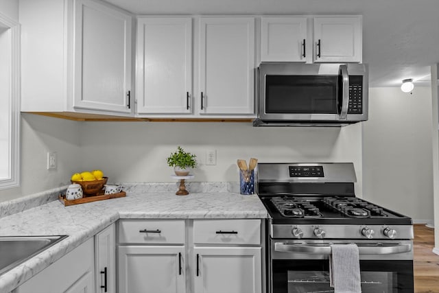 1024 N Fulbright Ave, Springfield, MO 65802 - kitchen featuring appliances with stainless steel finishes, white cabinets, and wood finished floors