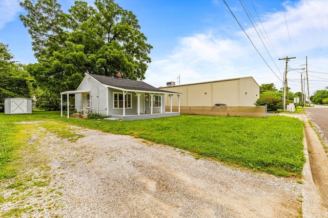 1024 N Fulbright Ave, Springfield, MO 65802 - back of property with a yard, covered porch, a storage shed, driveway, and a chimney