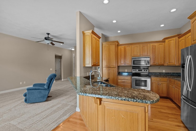 628 N Alexandria St, Nixa, MO 65714 - kitchen with appliances with stainless steel finishes, a peninsula, recessed lighting, dark stone counters, and a ceiling fan