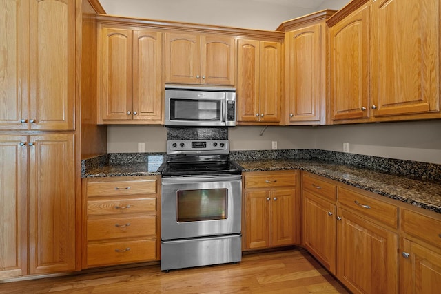 628 N Alexandria St, Nixa, MO 65714 - kitchen with stainless steel appliances, light wood-type flooring, dark stone countertops, and brown cabinets