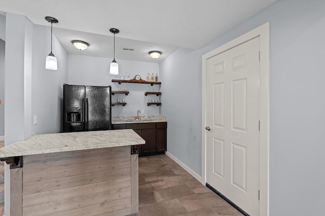 628 N Alexandria St, Nixa, MO 65714 - indoor wet bar featuring black fridge with ice dispenser, stone finish flooring, and decorative light fixtures