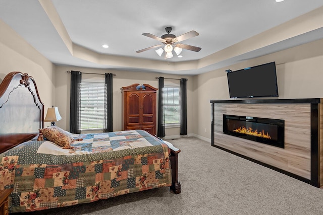 628 N Alexandria St, Nixa, MO 65714 - bedroom with a raised ceiling, carpet floors, a glass covered fireplace, recessed lighting, and a ceiling fan