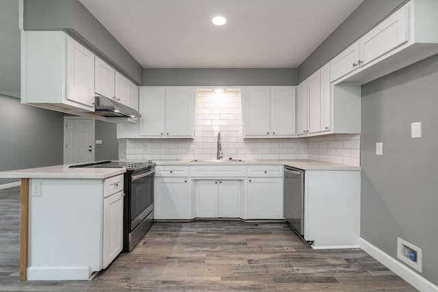 3512 S Ferguson Ave, Springfield, MO 65807 - kitchen with stainless steel appliances, under cabinet range hood, white cabinets, decorative backsplash, and dark wood-style flooring