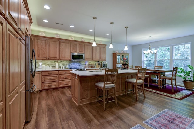 21791 Mill Creek Dr, Shell Knob, MO 65747 - kitchen with stainless steel microwave, light countertops, a kitchen breakfast bar, decorative backsplash, and dark wood-type flooring