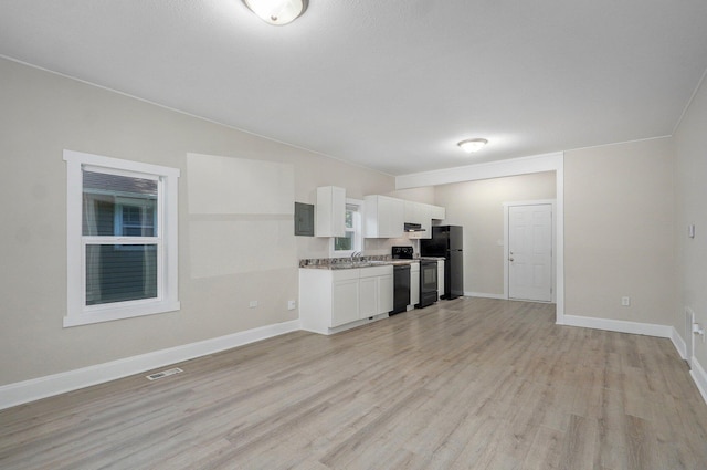 619 N Nettleton Ave, Springfield, MO 65802 - kitchen with black appliances, white cabinets, light wood finished floors, extractor fan, and open floor plan
