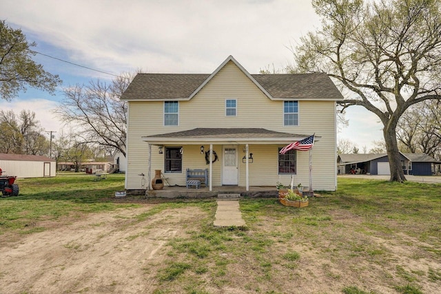 106 S Gilmore St, Miller, MO 65707 - view of front of property featuring covered porch, a front yard, an outbuilding, and roof with shingles
