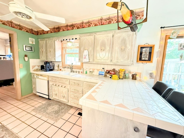 6424 W Farm Rd Unit 140, Springfield, MO 65802 - kitchen featuring white dishwasher, tile countertops, decorative backsplash, light tile patterned flooring, and a ceiling fan