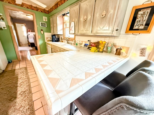 6424 W Farm Rd Unit 140, Springfield, MO 65802 - kitchen with tile counters, light tile patterned flooring, and decorative backsplash