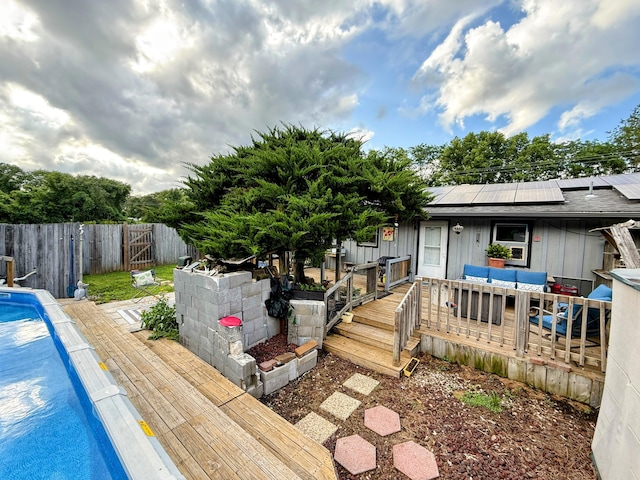 6424 W Farm Rd Unit 140, Springfield, MO 65802 - rear view of property with a deck, roof mounted solar panels, a fenced backyard, and board and batten siding